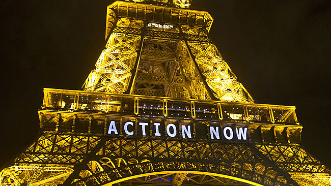 In this Sunday, Dec. 6, 2015, photo, the Eiffel Tower lights up with the slogan"Action Now"referring to the COP21, United Nations Climate Change Conference in Paris. The carbon footprint for the COP21 conference runs to thousands of tons, for the some 40,000 people, including heads of state, negotiators, activists and journalists, in Paris to hash out a ground-breaking international agreement to put a brake on global warming. (AP Photo/Michel Euler)